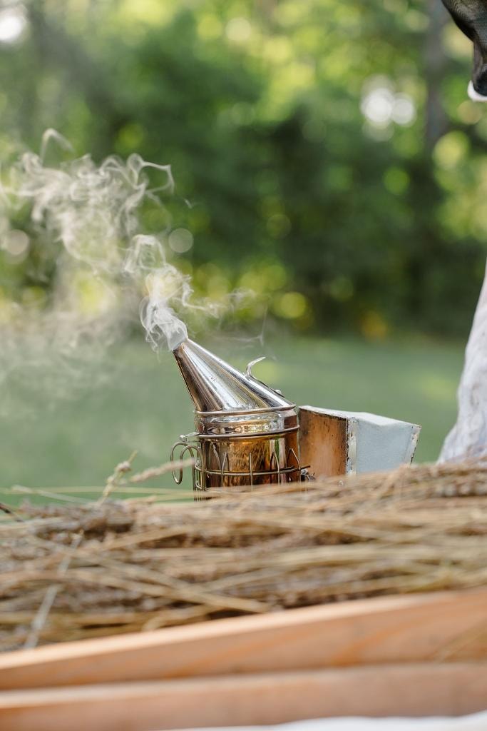 Golden honey dripping from a wooden dipper